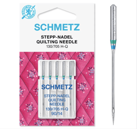 A package of SCHMETZ quilting needles (130/705 H-Q, size 90/14) with five needles in a plastic case, displayed on a pink, patterned quilt background. One needle is shown separately to the right.