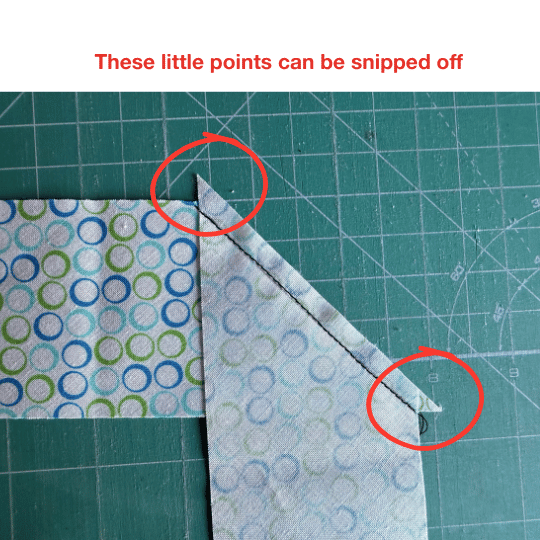 Close-up of a diagonal quilt binding seam showing the small fabric points at each end that can be snipped off before pressing the seam.