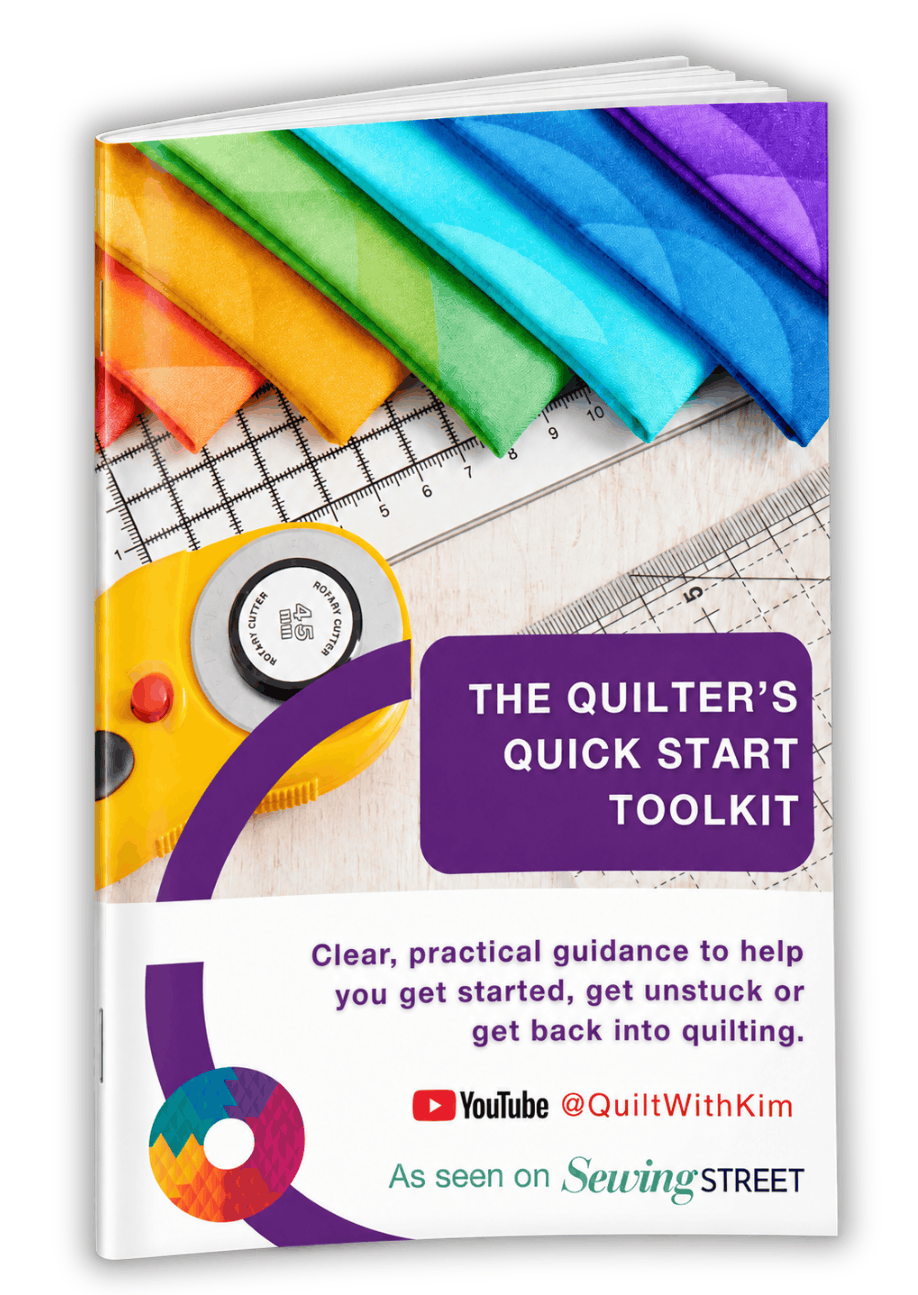Slim A4 booklet titled The Quilter’s Quick Start Toolkit, angled to show its spine and a few pages. The cover features colourful fabrics, quilting rulers and a yellow rotary cutter
