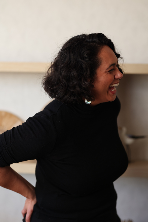 Alena Bennett on black top, hands on hips, laughing