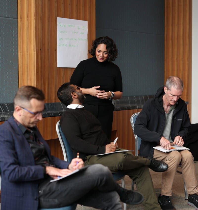 Alena Bennett wearing black top mentoring a group of men