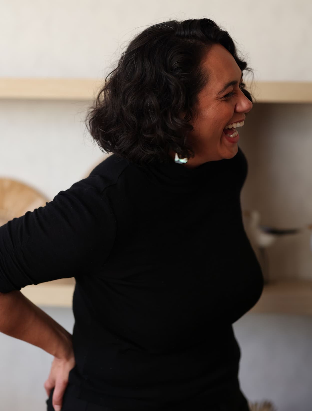 Alena Bennett on black top, hands on hips, laughing