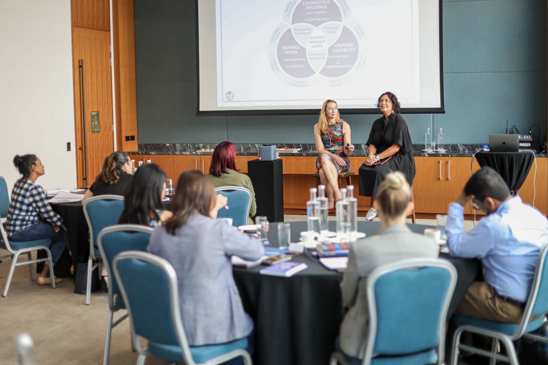 Alena Bennett Speaking In Front of a crowd in a Conference