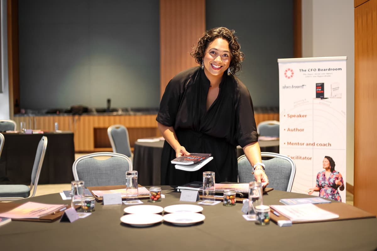 Alena Bennett in white top, putting books on table